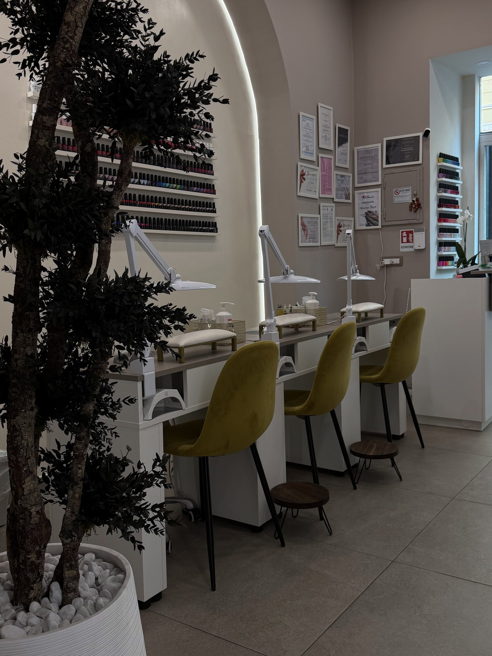 Certificati professionali e parete di smalti OPI colorati